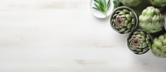 Poster - The white wooden table is adorned with a bowl filled with powder and fresh artichokes creating an appealing flat lay composition Ample space is available for text