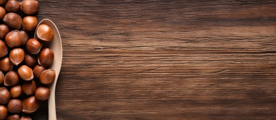 Aufkleber - A top down view of a spoon filled with shelled hazelnuts rests on a rustic wooden surface providing ample copy space for your textual needs