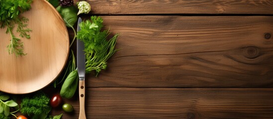 Poster - Copy space image of a wooden background with a white plate adorned with a fork and spoon alongside fresh herbs and greens as ingredients for cooking