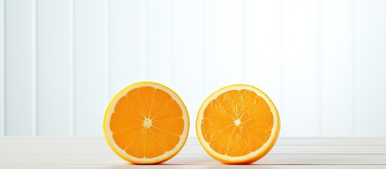 Poster - The cut halves of two oranges are positioned on a white wooden table leaving empty space for an image. Creative banner. Copyspace image
