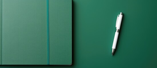 Poster - A top down view of a stylish green pen on a school notebook representing the concept of an office setting with a copy space image