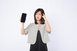 Asian woman is thinking the news on her mobile phone against a white background.