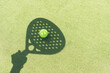 Paddle tennis racket shadow on balls.