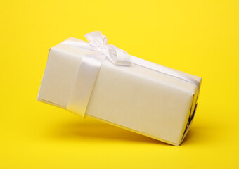 Wall Mural - White gift box with bow mockup floating on yellow background