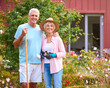 Portrait Of Loving Senior Retired Couple Outdoors At Home Working In Garden Together