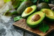 Avocados, a staple food, are halved on a wooden board