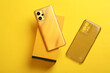 Modern new smartphone with box on yellow background. Top view