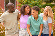 © Monkey Business - Portrait Of Two Teenage Children Standing With Parents Outdoors At Home In Summer Garden