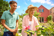 © Monkey Business - Teenage Grandson Helping Grandmother With Gardening At Home Learning About Plants And Nature