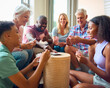 © Monkey Business - Three Generation Family Indoors At Home In Lounge Playing Game Of Cards Together