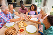 © Monkey Business - Three Generation Family Indoors At Home Doing Cheers With Water Before Eating Meal Together