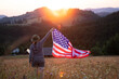 Woman with USA flag in magic sunset.