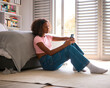 © Monkey Business - Anxious Teenage Girl Sitting On Bedroom Floor At Home With Mobile Phone Concerned About Social Media