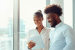 © GustavsMD - Business Colleagues Using Tablet in Office. Smiling African American business colleagues using a digital tablet together in a bright office setting.