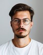 © Maelgoa - ID Photo for Passport : European young adult man with straight short black hair and blue eyes, thick mustache, with glasses and wearing a white t-shirt