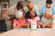 © Monkey Business - Three Generation Family Indoors At Home Celebrating Teenage Daughter's Birthday With Party And Cake