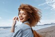 © SHOTPRIME STUDIO - Smiling Woman with Backpack, Enjoying a Happy Vacation on a Beach