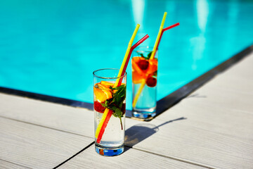 Two glass of cocktail by the pool