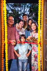 Gruhapravesh - indian asian family in traditional wear entering new home