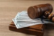Judge's gavel and money on wooden table, closeup