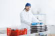 Worker in white coat holds cedar nuts in plastic vacuum bag. Concept eco food industry plant