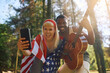 Cheerful American woman and her boyfriend taking selfie while having fun in nature.