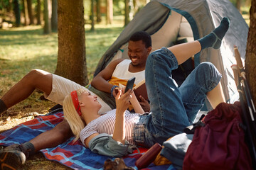 Young happy couple talking while enjoying in camping in nature.