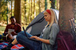 Young woman using laptop while camping with her boyfriend in nature.