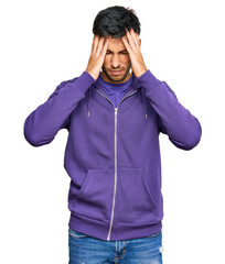 Wall Mural - Young handsome man wearing casual sweatshirt suffering from headache desperate and stressed because pain and migraine. hands on head.