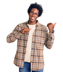 Wall Mural - handsome african american man with afro hair wearing casual clothes and glasses pointing to the back