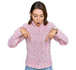 © Krakenimages.com - Young caucasian girl wearing wool winter sweater pointing down with fingers showing advertisement, surprised face and open mouth