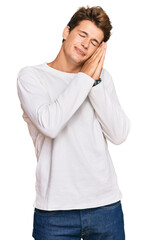 Wall Mural - Handsome caucasian man wearing casual white sweater sleeping tired dreaming and posing with hands together while smiling with closed eyes.