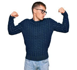 Poster - Young blond man wearing casual clothes and glasses showing arms muscles smiling proud. fitness concept.