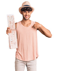 Canvas Print - Young hispanic man wearing summer hat holding map pointing finger to one self smiling happy and proud