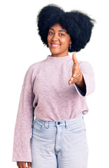 Sticker - Young african american girl wearing casual clothes smiling friendly offering handshake as greeting and welcoming. successful business.