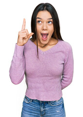 Poster - Young hispanic girl wearing casual clothes pointing finger up with successful idea. exited and happy. number one.