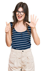 Wall Mural - Young beautiful caucasian girl wearing casual clothes and glasses showing and pointing up with fingers number six while smiling confident and happy.