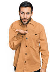 Poster - Young hispanic man wearing casual clothes looking at the camera blowing a kiss with hand on air being lovely and sexy. love expression.