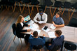 © artiemedvedev - Top view of a pro business meeting in a modern office. Mixed race team with a female CEO discuss project strategies, charts on paper and laptop. Corporate negotiation in a conference room.