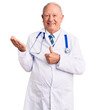 © Krakenimages.com - Senior handsome grey-haired man wearing doctor coat and stethoscope showing palm hand and doing ok gesture with thumbs up, smiling happy and cheerful