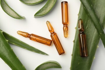 Sticker - Skincare ampoules and aloe leaves on white background, flat lay