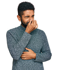 Poster - Young african american man wearing casual clothes smelling something stinky and disgusting, intolerable smell, holding breath with fingers on nose. bad smell