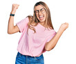 © Krakenimages.com - Hispanic young woman wearing casual t shirt and glasses very happy and excited doing winner gesture with arms raised, smiling and screaming for success. celebration concept.