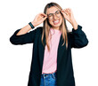 © Krakenimages.com - Hispanic young woman wearing elegant jacket and glasses winking looking at the camera with sexy expression, cheerful and happy face.