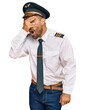 © Krakenimages.com - Handsome man with beard wearing airplane pilot uniform peeking in shock covering face and eyes with hand, looking through fingers with embarrassed expression.
