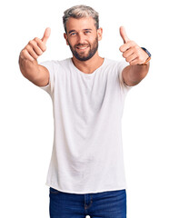 Poster - Young handsome blond man wearing casual t-shirt smiling making frame with hands and fingers with happy face. creativity and photography concept.