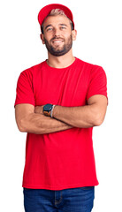 Poster - Young handsome blond man wearing t-shirt and cap happy face smiling with crossed arms looking at the camera. positive person.