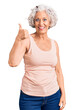© Krakenimages.com - Senior grey-haired woman wearing casual clothes smiling happy and positive, thumb up doing excellent and approval sign