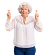 © Krakenimages.com - Senior grey-haired woman wearing casual clothes gesturing finger crossed smiling with hope and eyes closed. luck and superstitious concept.