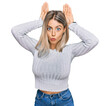 © Krakenimages.com - Beautiful blonde woman wearing casual clothes doing bunny ears gesture with hands palms looking cynical and skeptical. easter rabbit concept.